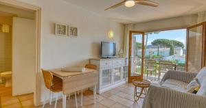 a living room with a tv and a couch and a table at Penyagolosa in Calella de Palafrugell