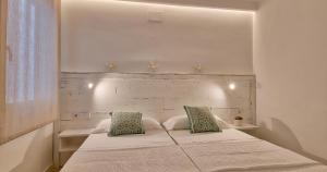 a bedroom with a white bed with two pillows at Llafranc Centre, Totally Refurbished in Llafranc