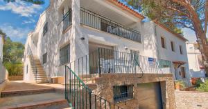 a white building with a balcony and stairs at Llafranc Centre, Totally Refurbished in Llafranc