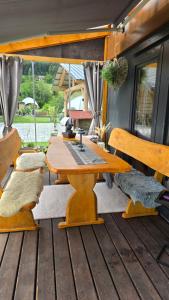 a wooden table and benches on a deck at Tiny House mit Fernblick in Verditz