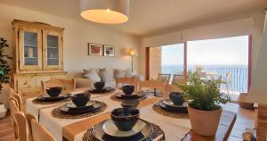 a living room with a table with chairs and a couch at Exclusive Position Front Line Apartments Calau in Calella de Palafrugell