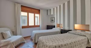 a hotel room with two beds and a window at Exclusive Position Front Line Apartments Calau in Calella de Palafrugell