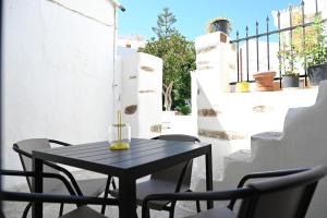 a black table and chairs on a balcony at MarGo House Kythnos in Kithnos