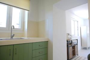 a kitchen with green cabinets and a sink at MarGo House Kythnos in Kithnos +25 photos