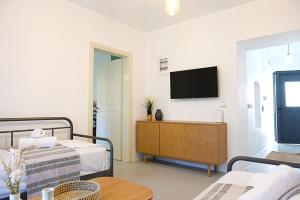 a room with a bed and a tv on a wall at MarGo House Kythnos in Kithnos