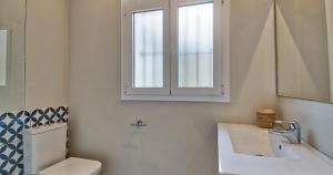 a bathroom with a toilet and a sink and a window at Llafranc Centre, Totally Refurbished in Llafranc