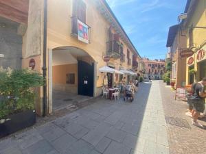 a street with people sitting at tables outside a building at CENTRAL LUXURY Rooms in Grugliasco