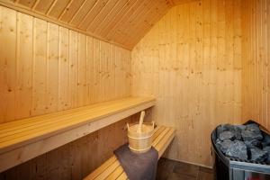 a wooden sauna with a trash can and a bucket at Der VechteSchober - Nordhorn in Nordhorn