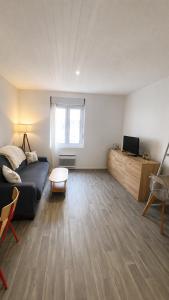 a living room with a couch and a tv and a table at Le Cocooning - 4 voyageurs - Jardin,Terrasse in Saint-Nazaire