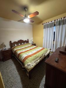 a bedroom with a bed and a ceiling fan at La Mary duplex in Federación