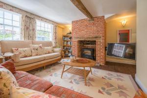 a living room with a couch and a fireplace at The Light House, Southwold in Southwold