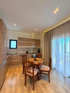 a kitchen with a wooden table and chairs and a dining room at Hotel Sole in Sarandë