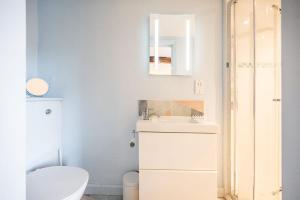a white bathroom with a toilet and a sink at The Light House, Southwold in Southwold +25 photos