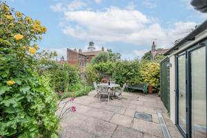 a patio with a table and chairs in a garden at The Light House, Southwold in Southwold
