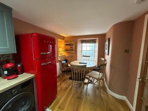 a kitchen with a red refrigerator and a table at Planners House in Saint Monance