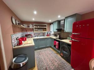 a kitchen with blue cabinets and a red refrigerator at Planners House in Saint Monance