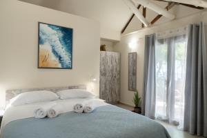a bedroom with a large bed with towels on it at Lava Beach Suites in Agia Galini +53 photos