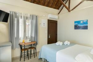 a hotel room with a bed and a table and a desk at Lava Beach Suites in Agia Galini
