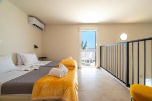 a bedroom with a large bed and a balcony at Prasonisi Lighthouse Asimenis in Prasonisi +60 photos