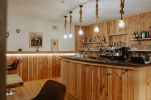 a bar in a restaurant with wooden walls at Naturhotel Wieserhof in Longostagno