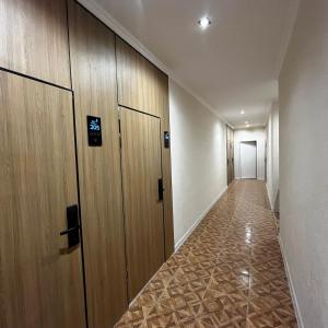 an empty hallway with wooden doors and a tile floor at Jetel Boutique Hotel in Almaty