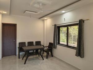 a dining room with a table and chairs and a window at Stay Origin, In Nashik in Nashik