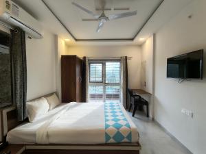 a bedroom with a bed with a ceiling fan and a window at Stay Origin, In Nashik in Nashik