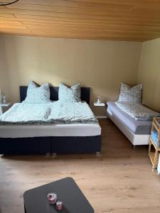 a bedroom with two beds with pillows and a table at Casa Tua An der Weinstraße 2 in Neustadt an der Weinstraße