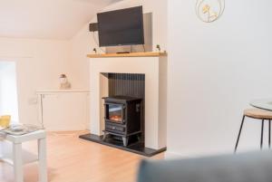 a living room with a fireplace with a tv above it at Egremont Hide Away - Perfect contractor accommodation - Close to Sellafield in Woodend