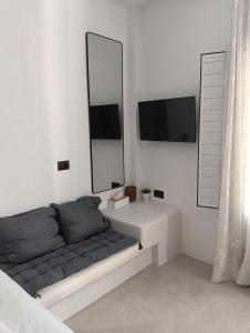 a white room with a couch and a mirror at Four season in Ios Chora