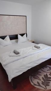 a large white bed with two pillows on it at Casa Madalina in Săpânța