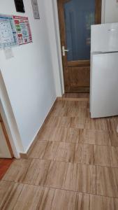 a kitchen with a white refrigerator and a wooden floor at Casa Madalina in Săpânța +18 photos