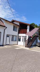 a white building with a staircase in front of it at Casa Madalina in Săpânța