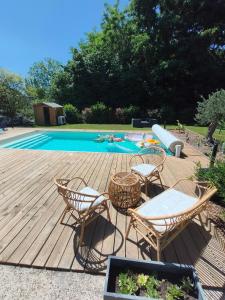 a wooden deck with chairs and a swimming pool at Maison proche du Circuit 24h du Mans, Moto GP, Le Mans Classic in Neuville-sur-Sarthe