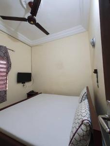 a bedroom with a bed and a ceiling fan at Hôtel Agbégbé in Abomey