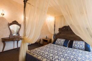 a bedroom with a canopy bed and a mirror at Hotel Kamelot in Omsk