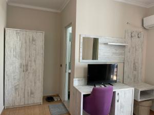 a room with a desk with a tv and a purple chair at Top view hostel in Durrës