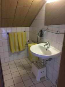 a bathroom with a white sink and yellow towels at Hotel & Restaurant Park Cafe ISA in Erfurt