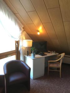 Zimmer im Dachgeschoss mit einem Schreibtisch mit einem Computer und einem Stuhl in der Unterkunft Hotel & Restaurant Park Cafe ISA in Erfurt