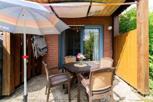 a table with chairs and an umbrella on a patio at Ort Lemkenhafen Sundbrise in Fehmarn