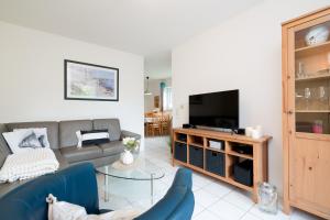 a living room with a couch and a television at Ort Lemkenhafen Sundbrise in Fehmarn