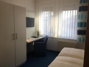 ein Hotelzimmer mit einem Schreibtisch und einem Bett in der Unterkunft Hotel & Restaurant Park Cafe ISA in Erfurt