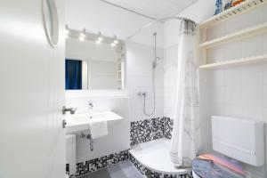 a white bathroom with a sink and a shower at Ort Lemkenhafen Sundbrise in Fehmarn +30 photos