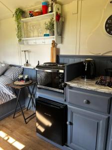 a kitchen with a stove top oven next to a table at Shepherds Rest by the Wye in Fawley Station