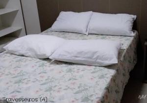 a bed with white sheets and pillows on it at Park Veredas Flat 310 Premium in Rio Quente +28 photos