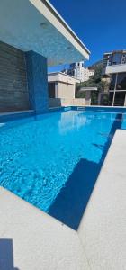 a swimming pool with blue water in front of a building at Lux Apartment Vidovic II in Rafailovici