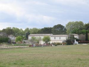 a white house with a field in front of it at Domaine de Christin Studios-Hôtel in Junas