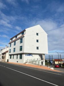 a white building on the side of a street at O NAUTICO suites in Cabana de Bergantiños