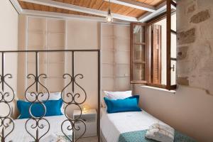 a bedroom with two beds with blue pillows at Aeria Apartments in Chania Town
