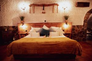 a bedroom with a large bed with a yellow blanket at Cueva del abuelo in El Molar